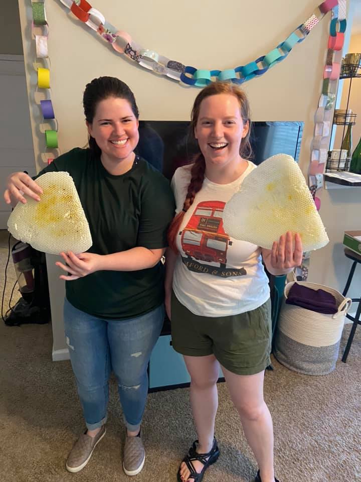 Rachel & her roommate hold up honeycomb extracted from her closet ceiling.