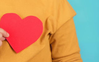 A person holding a paper cut-out heart