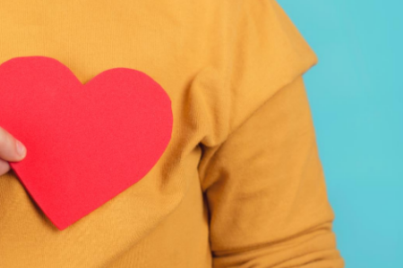 A person holding a paper cut-out heart