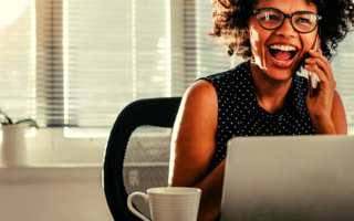 a woman sits at her desk and is happy