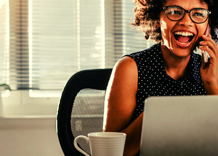 a woman sits at her desk and is happy