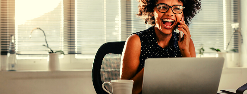 a woman sits at her desk and is happy