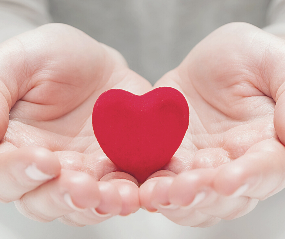 two hands holding a red heart