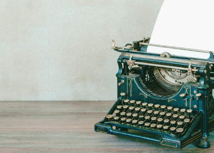 An old style typewriter sits on a table