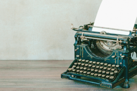 An old style typewriter sits on a table