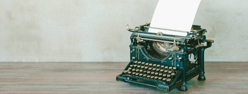 An old style typewriter sits on a table