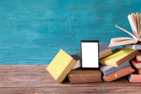 Books on a brown shelf with a teal background